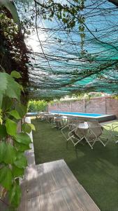 a row of chairs and a table and a swimming pool at Hotel Maioris Bellavista in Culiacán