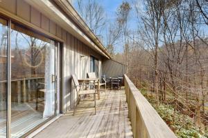 a wooden deck with a table and chairs on it at Rumbling Bald Resort Unit 2004 in Lake Lure