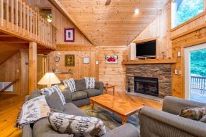 a living room with couches and a fireplace at Wunderland Cabin in Lake Lure