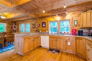 a kitchen with wooden cabinets and a dining room at Wunderland Cabin in Lake Lure