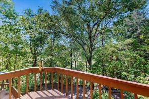 a wooden deck with trees in the background at Yopp's Treehouse in Lake Lure