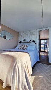 a large bedroom with a large bed and a window at Alma Flotante Muxía in Muxia