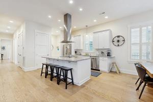 a kitchen with white cabinets and bar stools at Downtown Delight in Brevard