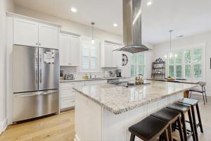 a kitchen with white cabinets and a stainless steel refrigerator at Downtown Delight in Brevard +22 photos