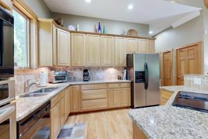 a kitchen with wooden cabinets and a stainless steel refrigerator at Rhymer Haven in Juno