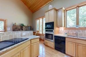 a kitchen with wooden cabinets and a black appliance at Rhymer Haven in Juno +19 photos