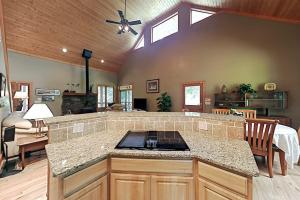 a kitchen with a counter top and a living room at Rhymer Haven in Juno