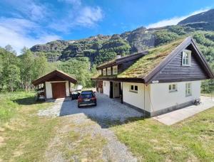 a house with a grass roof with a car parked in front at Aurlandsdalen in Aurland