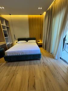 a bedroom with a bed and a wooden floor at EFFÉI Boutique Hotel in Sarandë