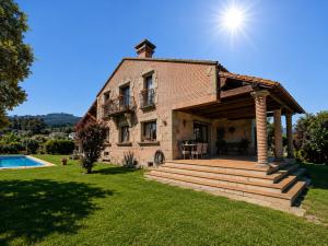 a large brick house with a patio and a pool at Vila Xocas in Baiona