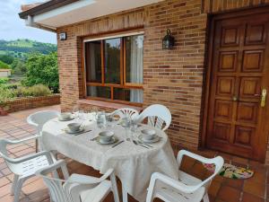 a table with white chairs on a patio at La Casuca de Marisa in Solórzano