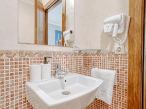 a bathroom with a sink and a mirror at Aida's Hostal in Puentes de García Rodríguez