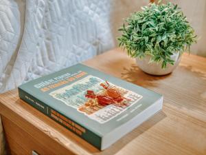 a book sitting on a table with a potted plant at Aida's Hostal in Puentes de García Rodríguez