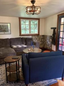 a living room with a couch and a table at Cabin by the Creek in Roberts Creek