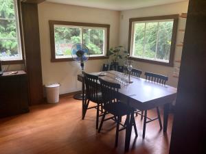 a dining room with a table and chairs and a fan at Cabin by the Creek in Roberts Creek +6 photos