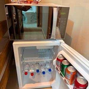 an open refrigerator filled with water bottles and soda cans at Guaru Inn Hostel in Guarulhos