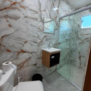 a bathroom with a marble wall at Guaru Inn Hostel in Guarulhos