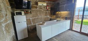 a kitchen with a white refrigerator and a microwave at A Cabana in Geres