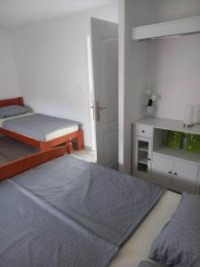 a small bedroom with two beds and a cabinet at Holiday Home Dalia with Private Pool in Blagaj