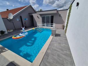 a swimming pool in front of a house at Holiday Home Dalia with Private Pool in Blagaj