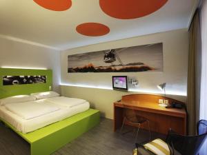ein Schlafzimmer mit einem Bett und einem Schreibtisch mit Computer in der Unterkunft ibis Styles Luzern in Luzern + 97 Fotos