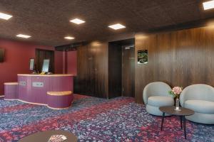 a lobby with two chairs and a desk and a table at b-smart hotel Widnau in Widnau