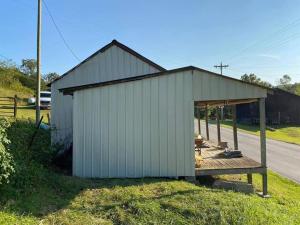 a large white building with a porch on the side of a road at Mountain Memories Cabin Rental in Booneville +19 photos
