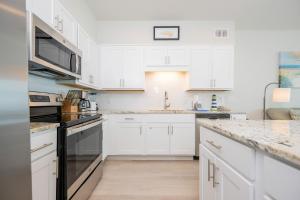 a white kitchen with white cabinets and appliances at Sea Glass 305 in Gulf Shores