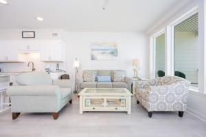 a living room with a couch and chairs and a table at Sea Glass 305 in Gulf Shores