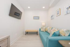 a living room with a blue couch and a tv at Sea Glass 305 in Gulf Shores +30 photos