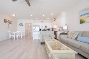 a living room with a couch and a table and a kitchen at Sea Glass 305 in Gulf Shores