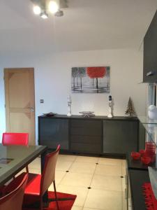 a kitchen with red chairs and a black counter top at Gite Chamonix Mont Blanc LYRET in Chamonix
