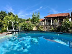 a swimming pool in front of a house at Casa María da Reza in Ribadavia