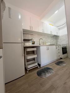 a kitchen with white cabinets and a white refrigerator at Apartman Ivana in Kraljevo