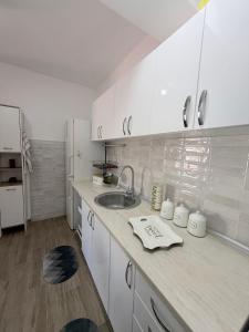 a white kitchen with a sink and a counter at Apartman Ivana in Kraljevo