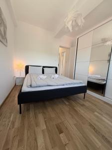 a large bed in a room with a wooden floor at Apartman Ivana in Kraljevo
