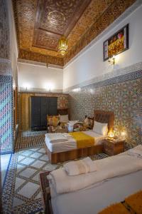 a bedroom with two beds and a coffered ceiling at Riad Fes iline Medina in Fez