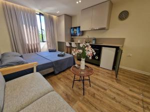 a living room with a bed and a table with flowers at Central Bazaar with Parking in Tirana