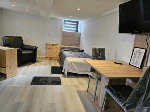 a bedroom with a bed and a desk and a television at Asanov Retreat in Northeim