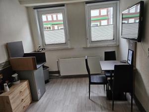 an empty room with a table and two windows at Asanov Retreat in Northeim