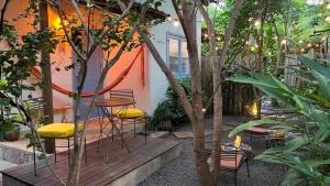 a patio with chairs and a table and some trees at Chalés Calima in Lençóis