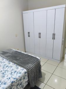 a bedroom with white cabinets and a bed at Apartamento central 1 quarto in Passo Fundo +5 photos
