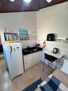 a small kitchen with a refrigerator and a table at Pousada Moradia da Fabi in Bragança Paulista