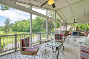 a screened porch with chairs and tables and windows at Cameron Lakeside in Lake Junaluska