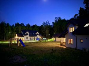a yard with a house and a playground at night at Lisia Górka in Debina