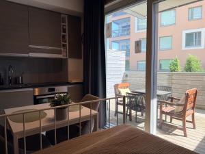 a kitchen and a balcony with a table and chairs at The Seabreeze Terrace Apartment in Turku