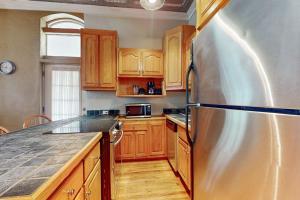 a kitchen with wooden cabinets and a stainless steel refrigerator at Mountain Stream Haven in Whittier +15 photos