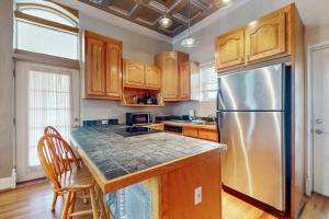a kitchen with wooden cabinets and a stainless steel refrigerator at Mountain Stream Haven in Whittier