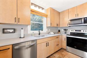 a kitchen with wooden cabinets and stainless steel appliances at Upper Lakeshore Living in Lake Junaluska