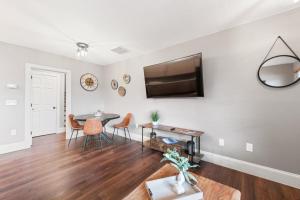 a living room with a table and a television on a wall at Lower Lakeshore Living in Lake Junaluska